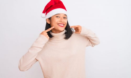 Young,Beautiful,Chinese,Woman,Wearing,Christmas,Santa,Hat,Over,Isolated